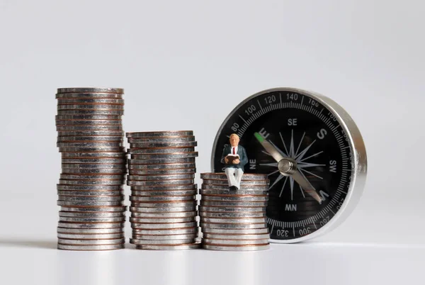 Hombre Miniatura Sentado Montón Monedas Leyendo Libro Delante Brújula — Foto de Stock