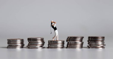 Bir yığın bozuk para ve minyatür bir golfçü..