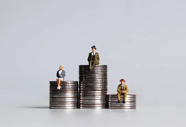 Personas Miniatura Sentadas Pilas Monedas Tres Alturas Diferentes —  Fotos de Stock