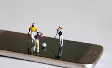 Akıllı telefonlarda golf oynayan minyatür insanlar..