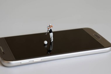 Akıllı telefonlarda golf oynayan minyatür insanlar..