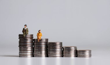 Grafik şeklinde bozuk paraların üzerinde oturan minyatür insanlar..