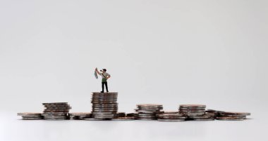 Bozuk para yığınında balık tutan minyatür bir adam..