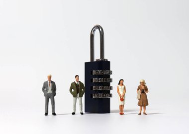 Kombinasyon kilidinin yanında duran minyatür insanlar.