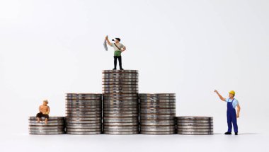 Minyatür insanlar ve bozuk para yığınları.