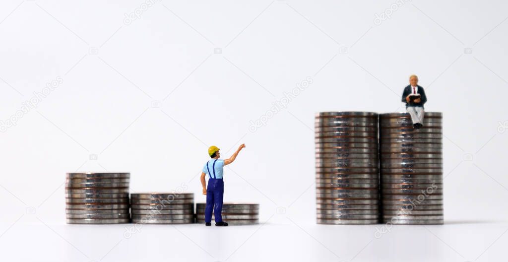 Stair-shaped coin piles and a miniature man sitting on the tower-shaped coin piles. The back of a miniature man pointing to a pile of coins.