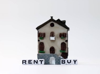 'BUY' ve 'RENT' metinlerinin beyaz küpü minyatür bir evle.