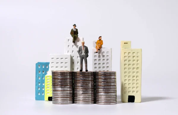 Мініатюрні Люди Сидять Мініатюрних Будівлях Мініатюрних Людей Стоять Палях Монет — стокове фото