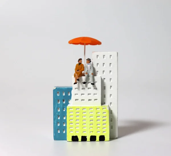 Una Pareja Ancianos Miniatura Sentados Con Paraguas Naranja Edificio Miniatura —  Fotos de Stock