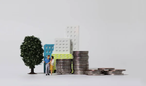 Ein Miniaturpaar Und Ein Haufen Münzen Mit Miniaturbaum Und Miniaturbau — Stockfoto