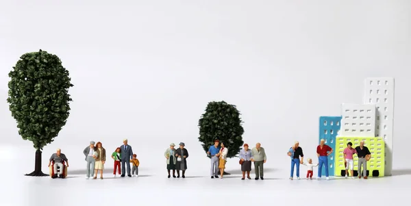 Jede Der Verschiedenen Miniaturfamilien Steht Vor Miniaturbäumen Und Miniaturgebäuden — Stockfoto