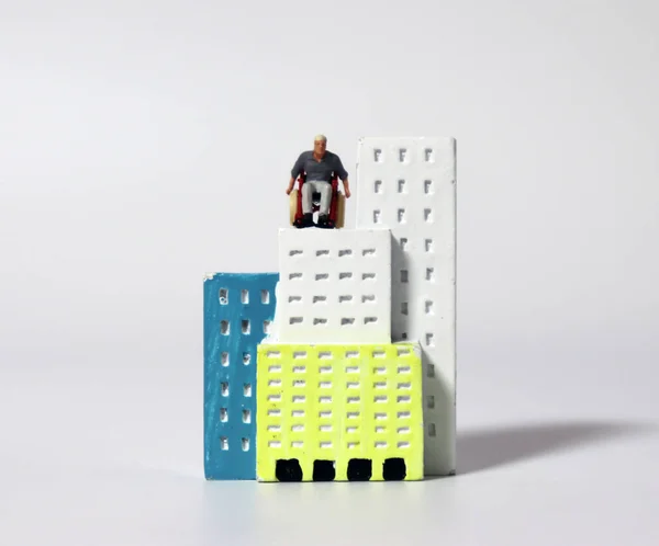 Ein Miniaturmann Rollstuhl Einem Miniaturgebäude — Stockfoto
