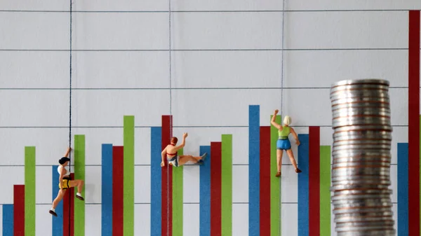 Miniature people climbing up a bar graph. Business performance and competitive concepts.