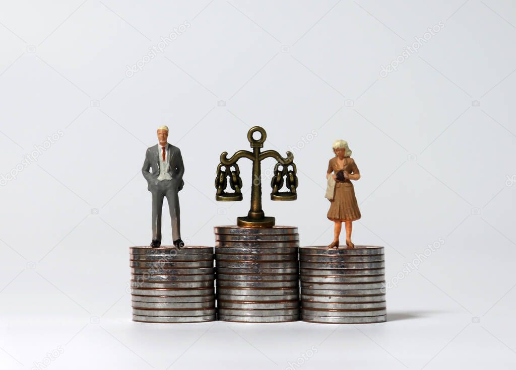 Miniature people standing on a pile of coins of the same height.