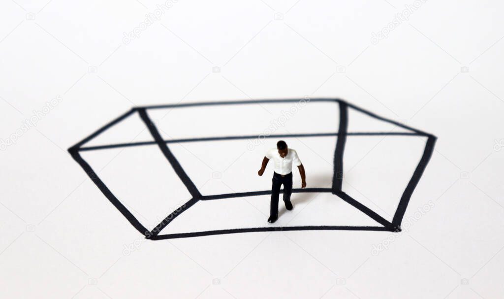 A miniature black man in a rectangle of black solid lines. Concepts for race and invisible walls.