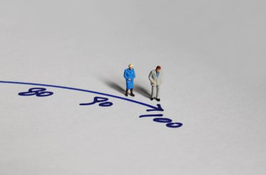 100 numaranın önünde duran yaşlı bir çift..