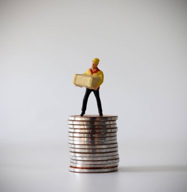 Bozuk para yığınının üzerinde duran minyatür bir kurye..