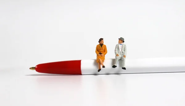 Kırmızı Tükenmez Kalem Üzerinde Oturan Minyatür Yaşlı Bir Çift — Stok fotoğraf
