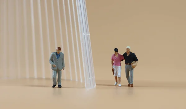 Miniature people separated by transparent walls.