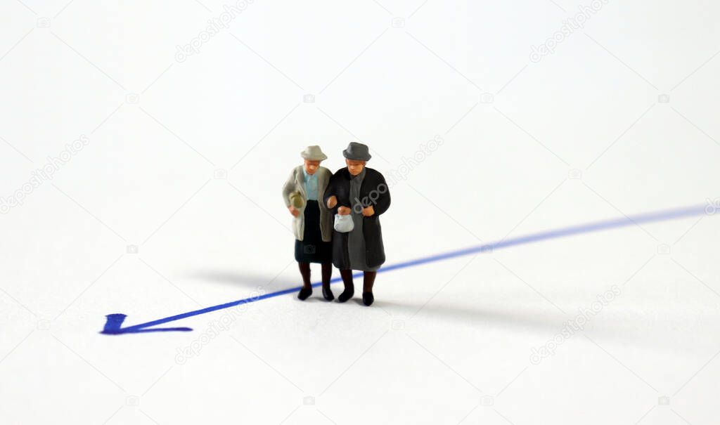 Miniature homosexual couple standing next to the blue arrow line.