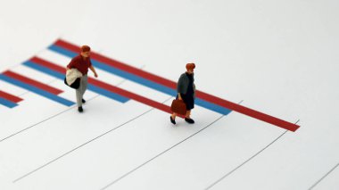 İnsanlar arasındaki gelir açığının büyümesi kavramı. Çubuk grafikte duran iki minyatür insan..