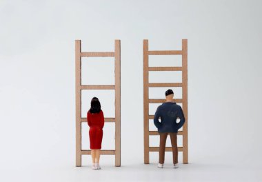 Farklı merdivenlerin önünde duran minyatür erkek ve kadınlar. Toplumda kadın ve erkek için ayrımcılık kavramı.