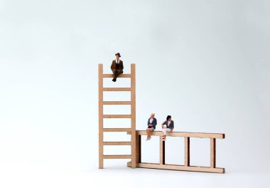 Tahta merdivende oturan minyatür bir adam ve kadın. Erkeklere yönelik güç yapısı kavramı.
