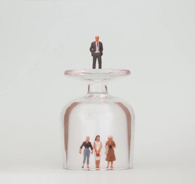 Cam bardakta üç minyatür kadın ve cam bardağın üstünde minyatür bir adam.. 