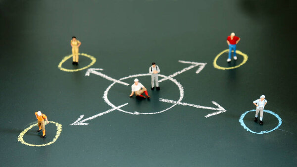 Miniature people each standing in a different circle. The concept of social divergence between people.