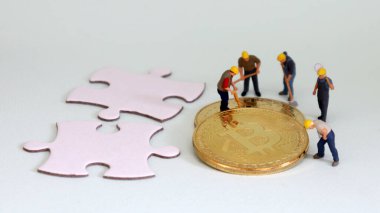 Bitcoin 'in etrafında iki parça yapboz ve minyatür işçi var..