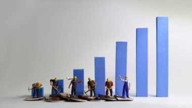 Mavi çizginin üzerinde duran minyatür işçiler. Asgari ücret artışı kavramı.