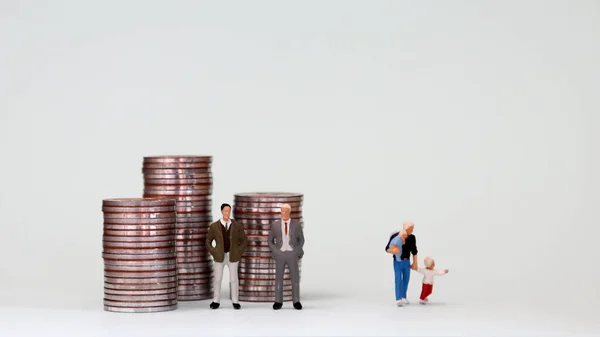 两个矮小的男人站在一堆硬币前 一个矮小的男人站在她的孩子面前 — 图库照片