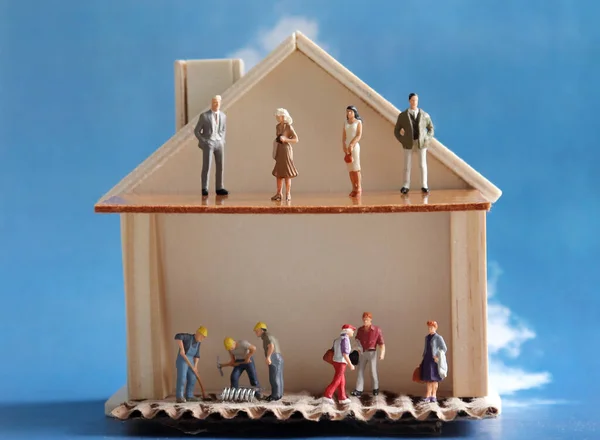 Miniature houses and miniature people. The concept of income gap by household.