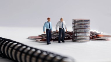 Minyatür adamlar ve madeni paralar.