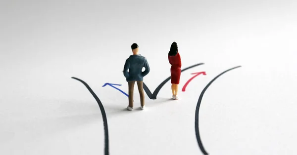 性别分工的概念 一个身材矮小的男人和一个身材矮小的女人站在两条不同的路上 — 图库照片