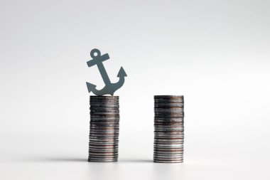 Aynı yükseklikte iki sikke ve bir minyatür çapa..