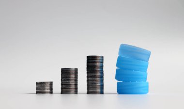 Üç yığın bozuk para ve tek kullanımlık plastik şişe kapağı..