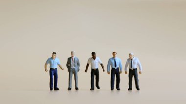 Çeşitli minyatür insanlar yan yana duruyor..
