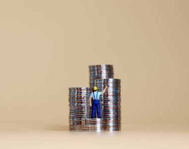 Bozuk para yığınları olan minyatür bir adam..