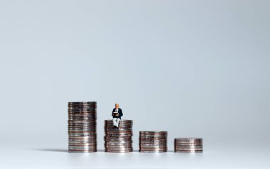 Emeklilik fonu konsepti. Bozuk para ve minyatür insanlar..