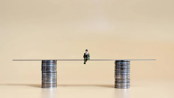 Miniature Man Sitting Two Piles Coins — Stock Photo, Image