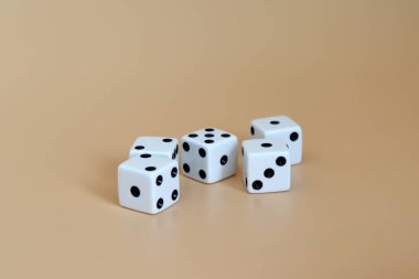 Yumuşak kahverengi arkaplanda beş zar.