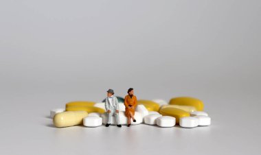 Hapın üzerinde oturan minyatür yaşlı bir çift.