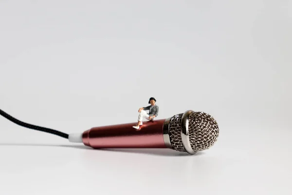 Een Miniatuur Vrouw Zittend Een Roze Microfoon — Stockfoto
