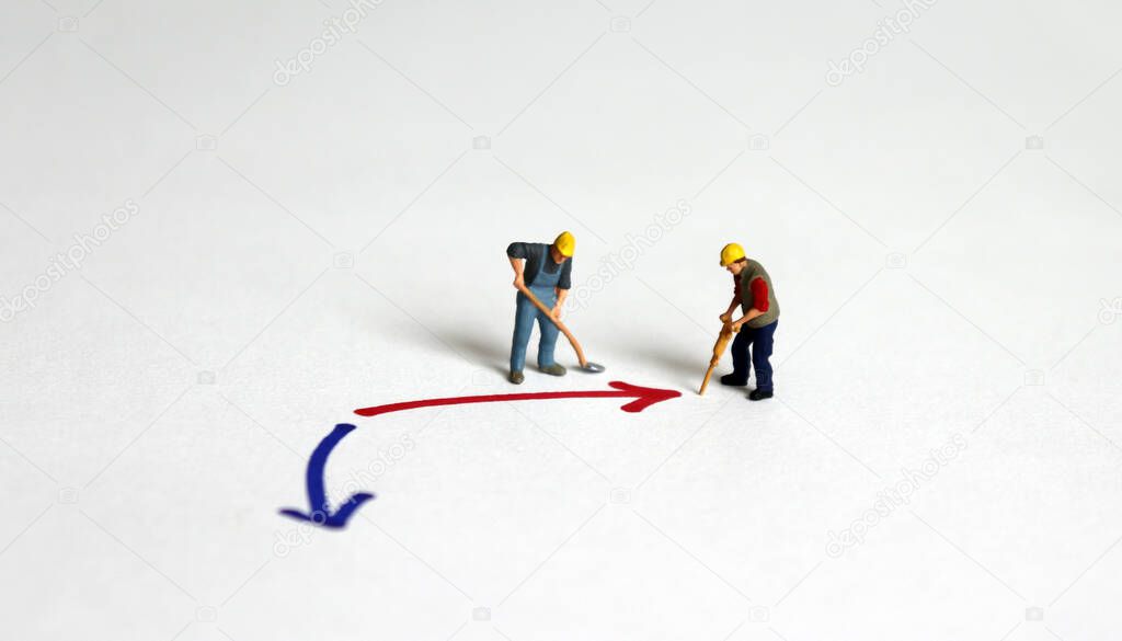 Two miniature worker next to the red arrow with the blue arrow.