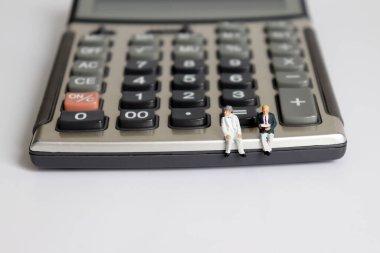 Hesap makinesinde oturan iki minyatür yaşlı adam..