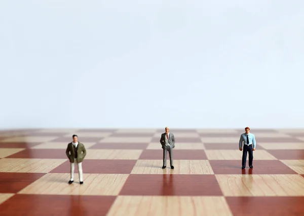 Three Miniature Men Standing Men Chessboard — Stock Photo, Image