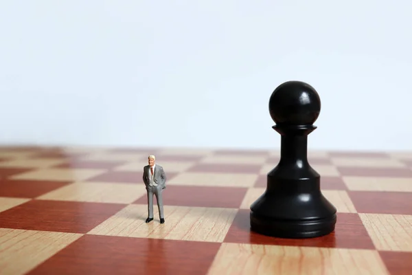Miniature Man Standing Side Side Black Pawn Chessboard — Stock Photo, Image
