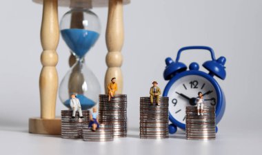 Minyatür insanlar ve bozuk para yığınları. Gelir ve zaman yoksulluğu arasındaki ilişki konsepti.