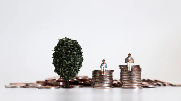 Pessoas Miniatura Sentadas Uma Pilha Moedas Segurando Seu Bebê — Fotografia de Stock